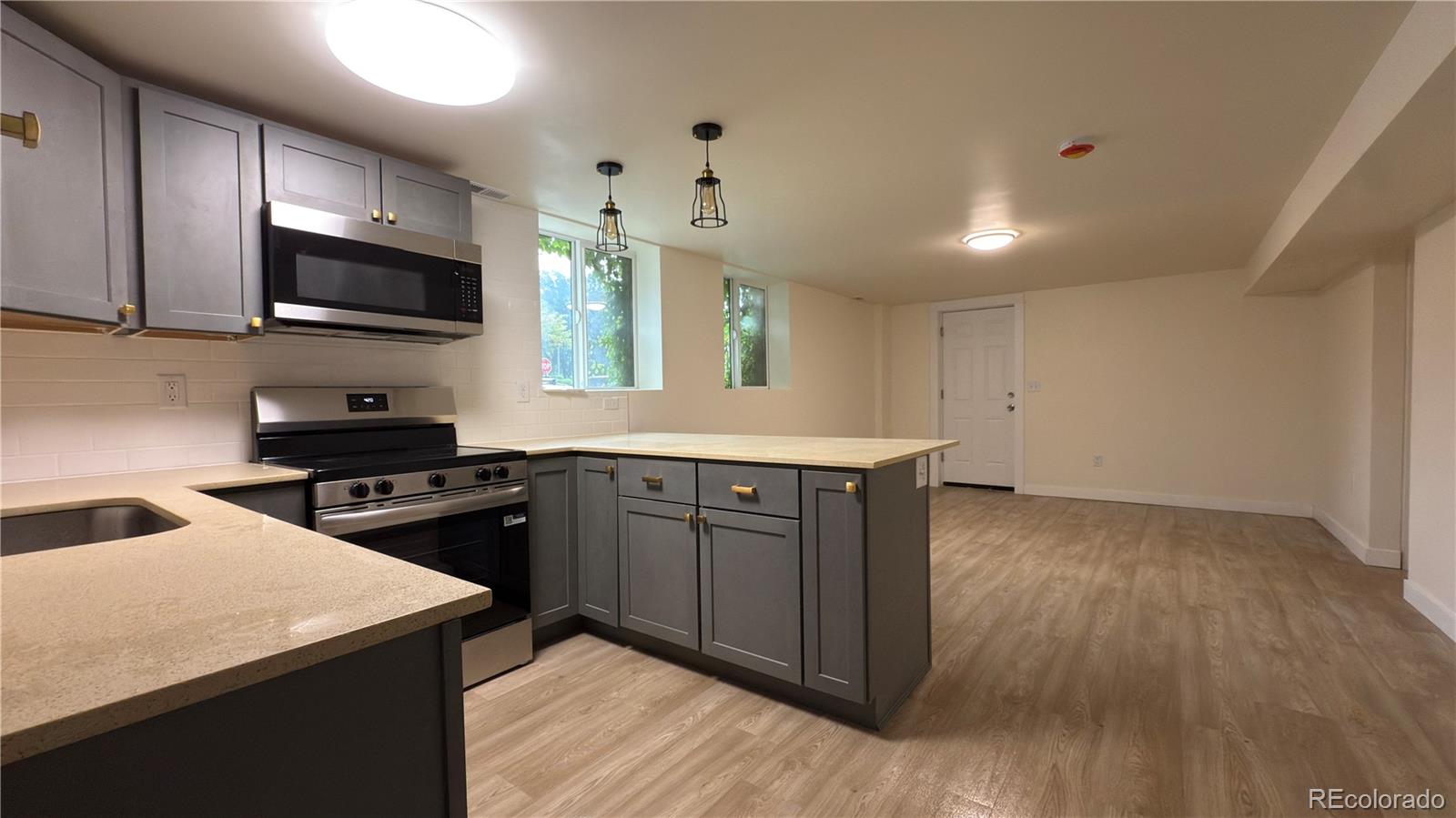 2201 South High Street, Unit 1832 Denver, CO 80210 - Photo 2 of 9 a kitchen with stainless steel appliances granite countertop a stove a sink and a microwave