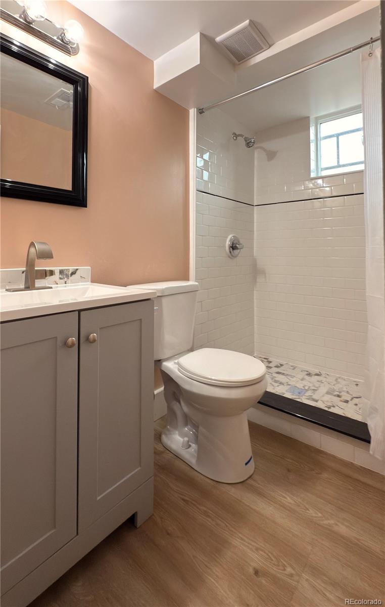 2201 South High Street, Unit 1832 Denver, CO 80210 - Photo 5 of 9 a bathroom with a toilet sink and mirror