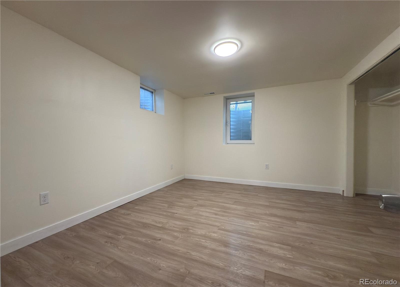 2201 South High Street, Unit 1832 Denver, CO 80210 - Photo 6 of 9 an empty room with wooden floor and windows