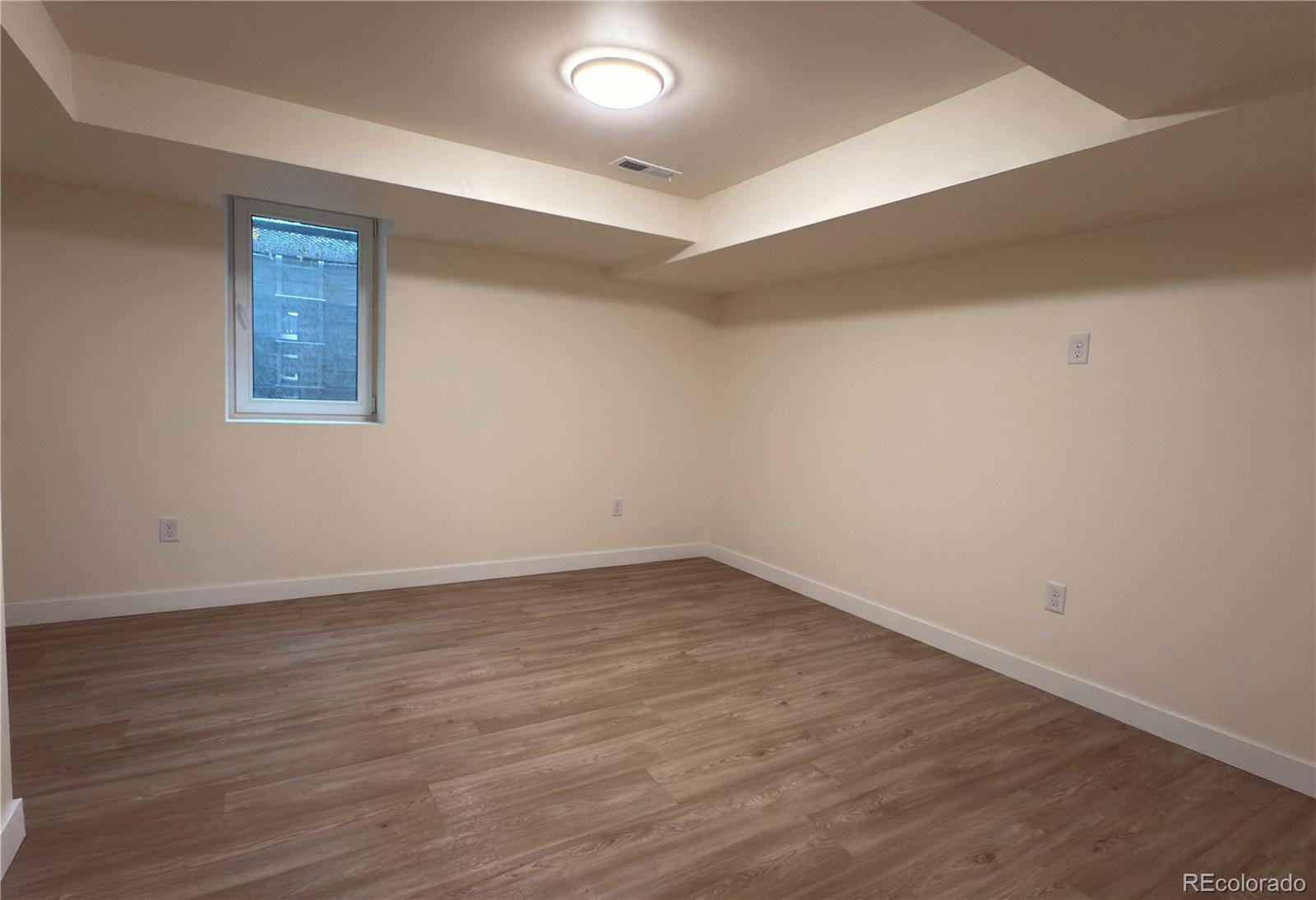 2201 South High Street, Unit 1832 Denver, CO 80210 - Photo 8 of 9 a view of an empty room with wooden floor and a window