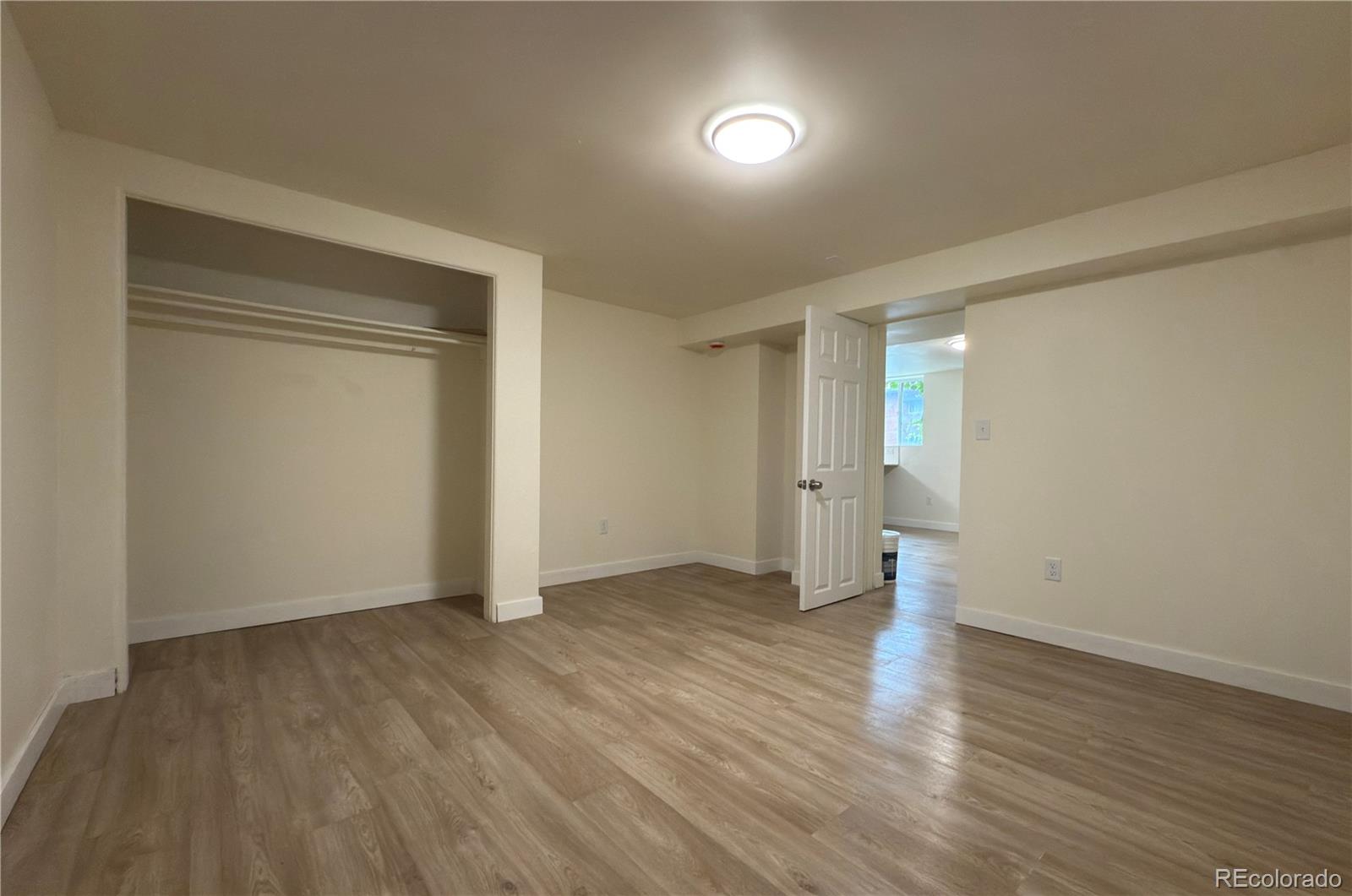 2201 South High Street, Unit 1832 Denver, CO 80210 - Photo 9 of 9 an empty room with wooden floor and windows