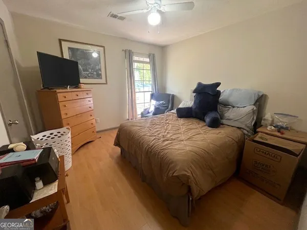 a bedroom with a bed and flat tv screen on the dresser
