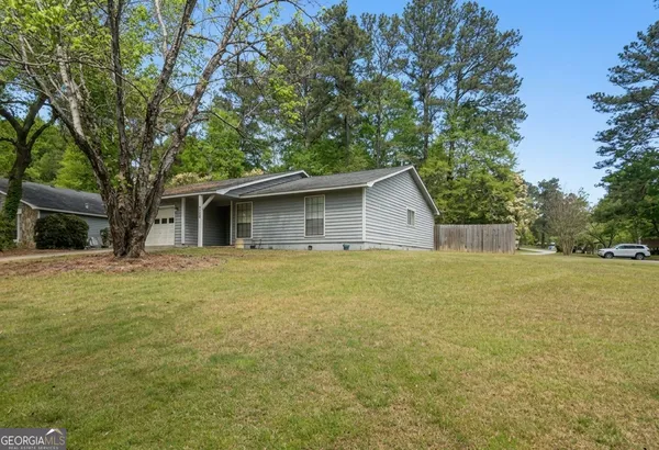 a view of a house with backyard and trees