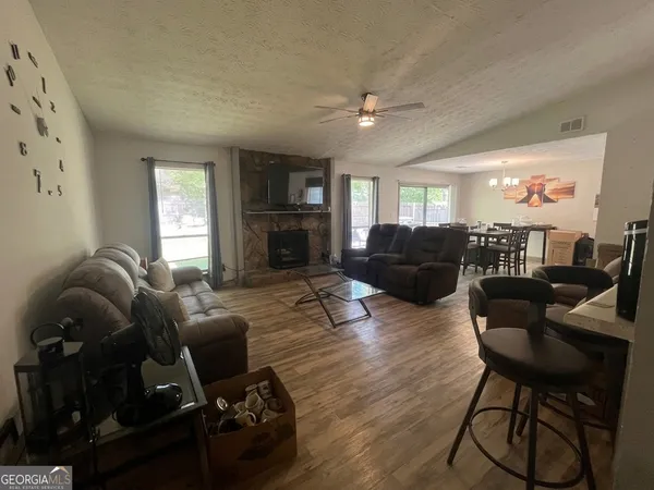 a living room with furniture and a flat screen tv with wooden floor
