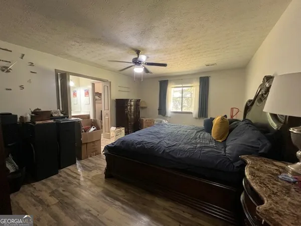 a spacious bedroom with a bed and wooden floor