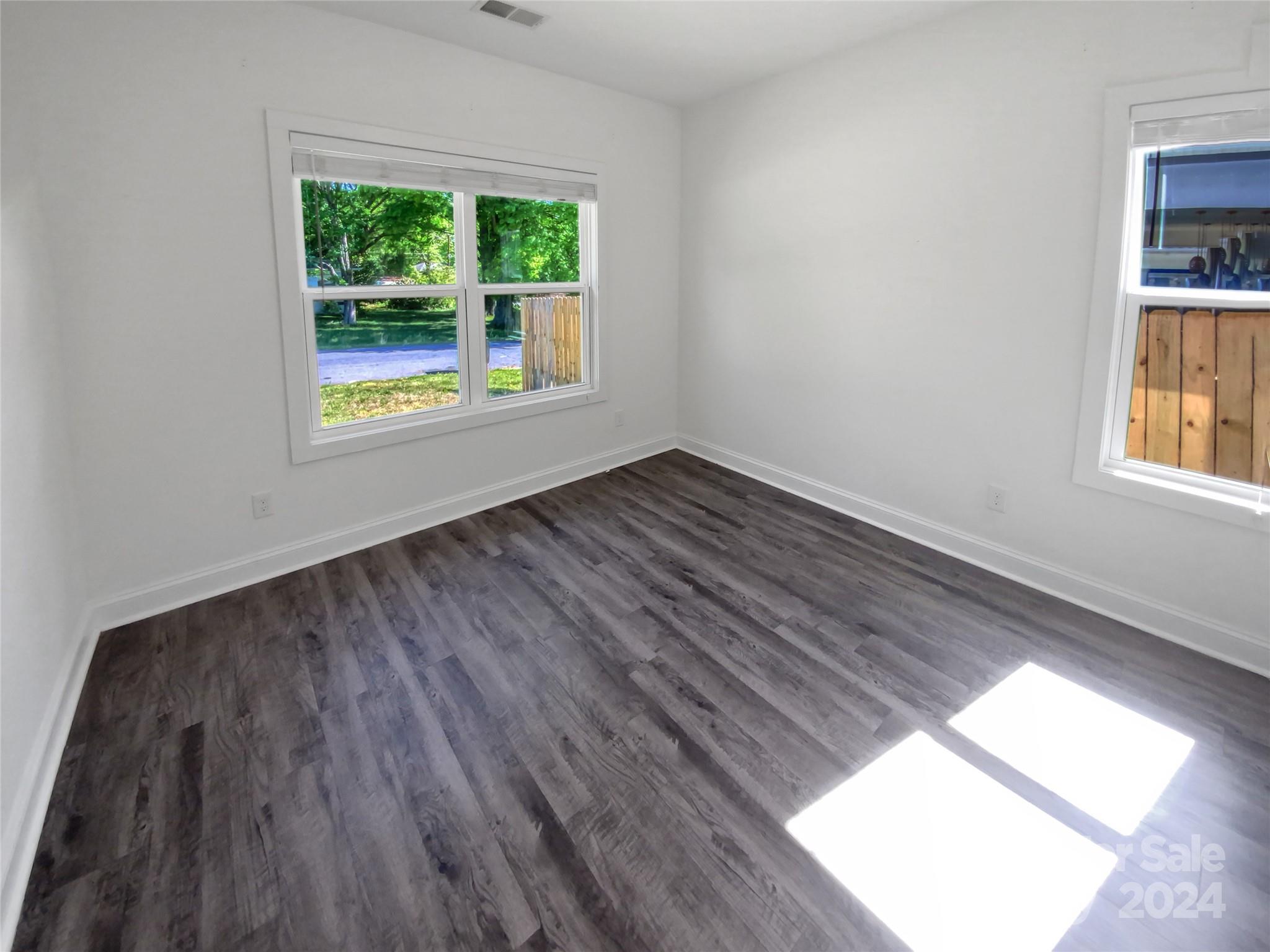 6110 Robinson Church Road Charlotte, NC 28215 - Photo 11 of 17 an empty room with wooden floor and windows