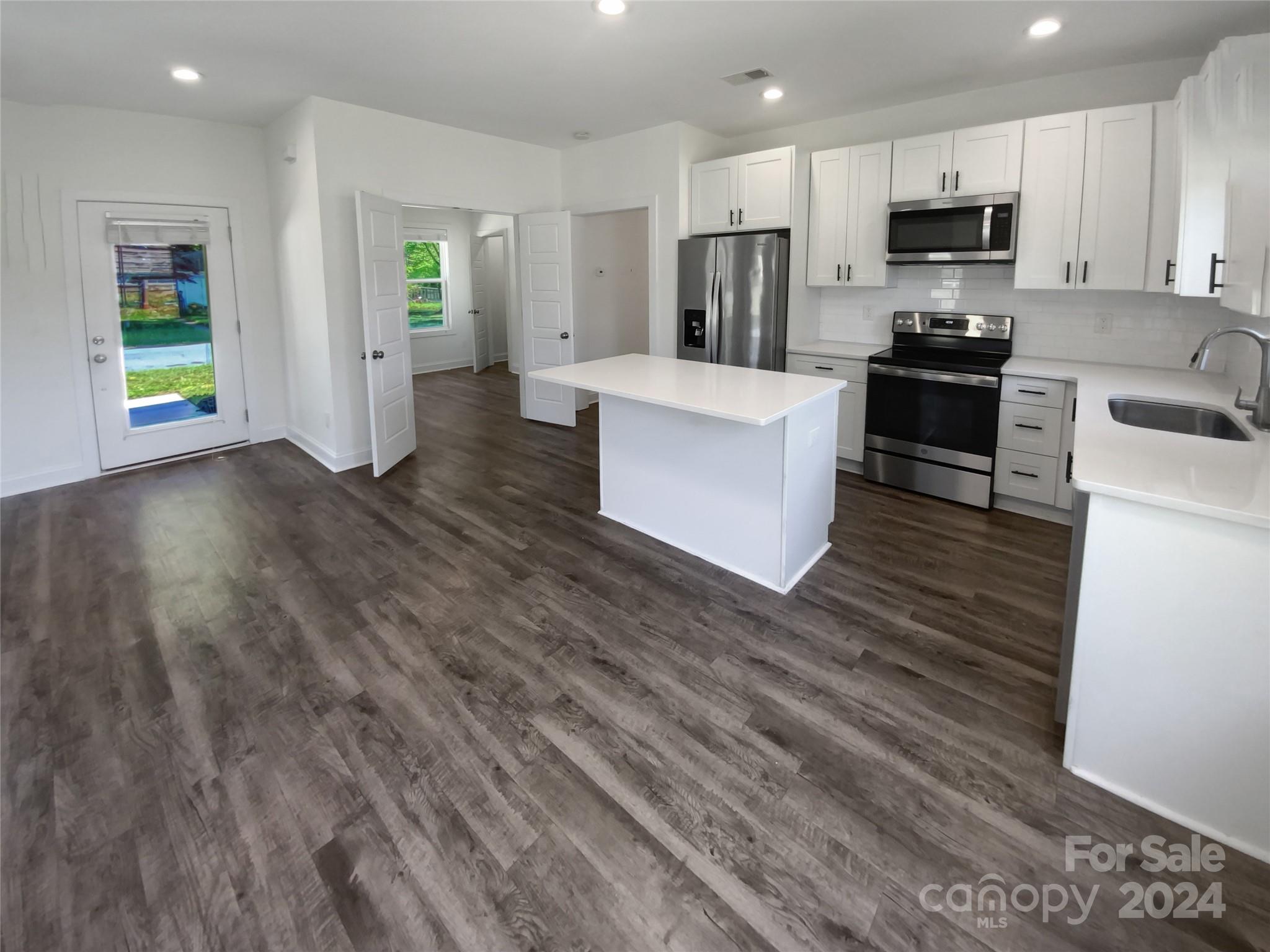6110 Robinson Church Road Charlotte, NC 28215 - Photo 2 of 17 a large kitchen with stainless steel appliances kitchen island a large counter top and a stove top oven
