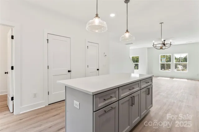 a kitchen with white cabinets and window