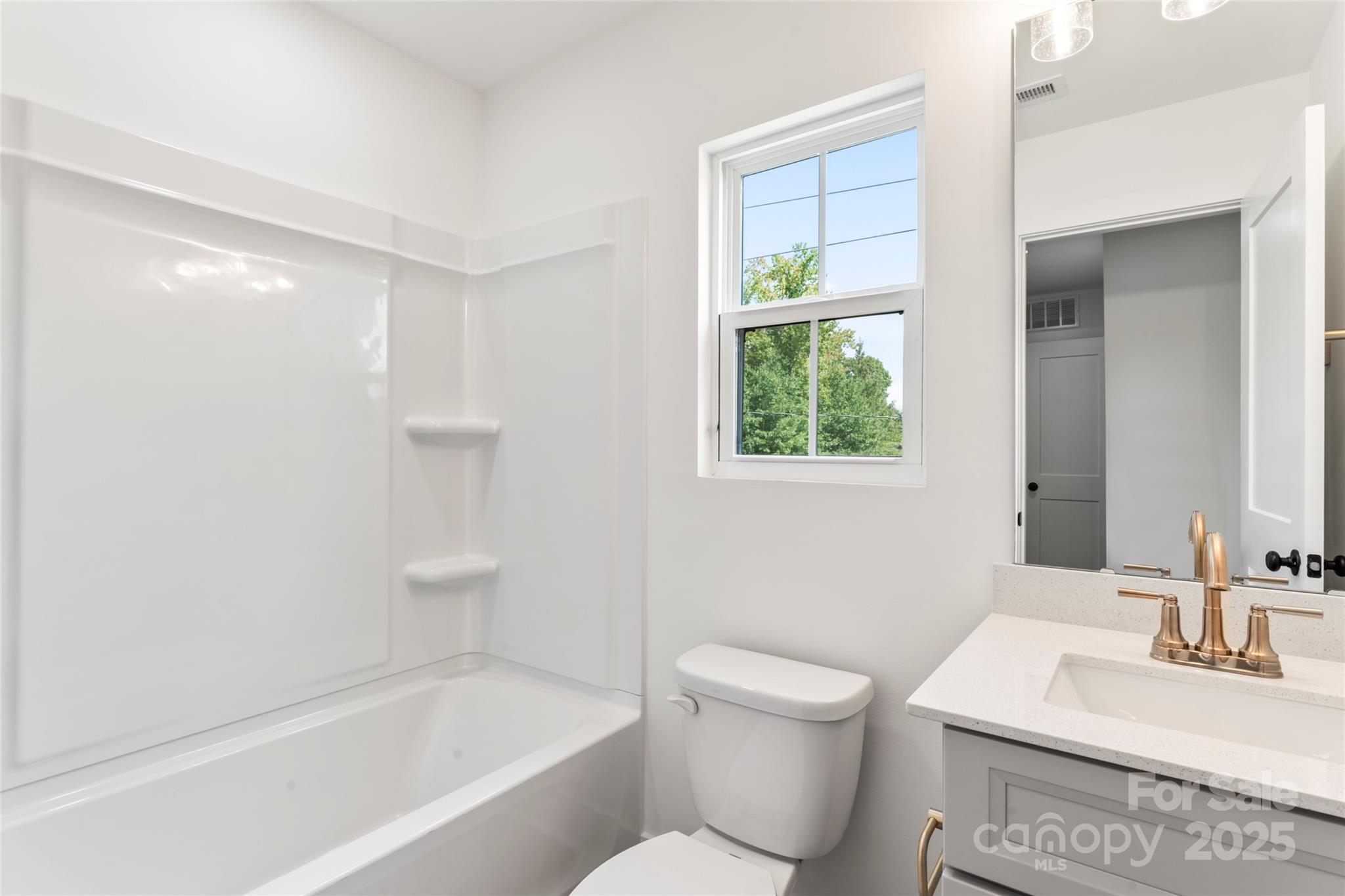 418 Bogue Drive, Unit 21 Fort Mill, SC 29708 - Photo 23 of 42 a bathroom with a bathtub a sink a toilet and a window
