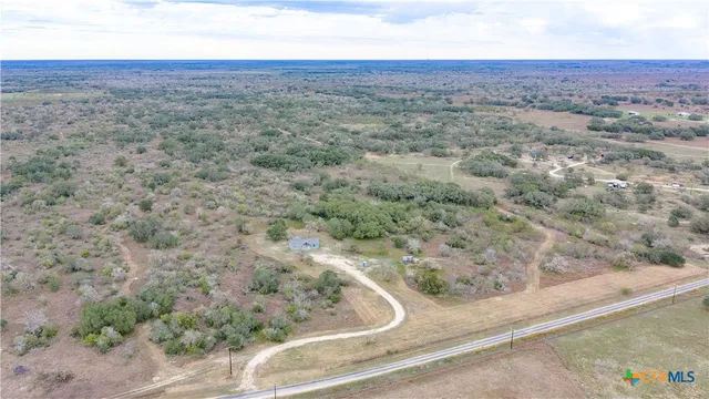 an aerial view of house with yard and mountain view in back