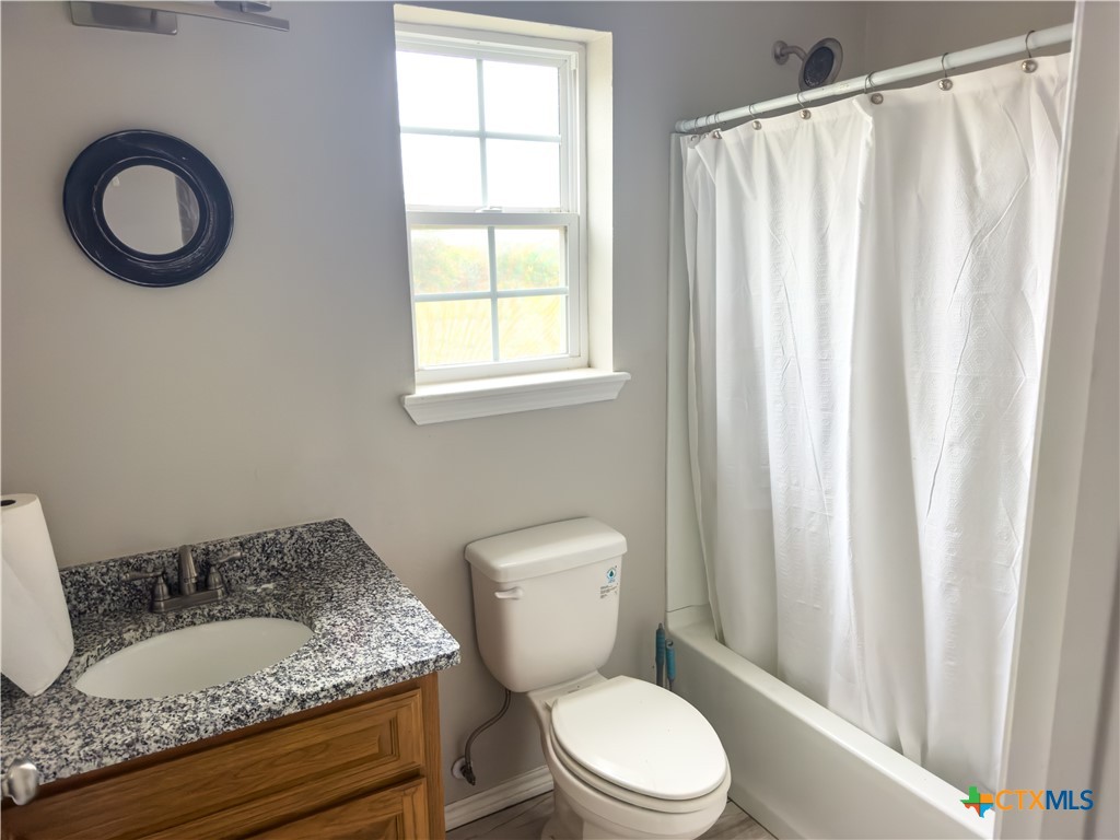 618 McGuill Road Goliad, TX 77963 - Photo 44 of 48 a bathroom with a granite countertop toilet sink and mirror
