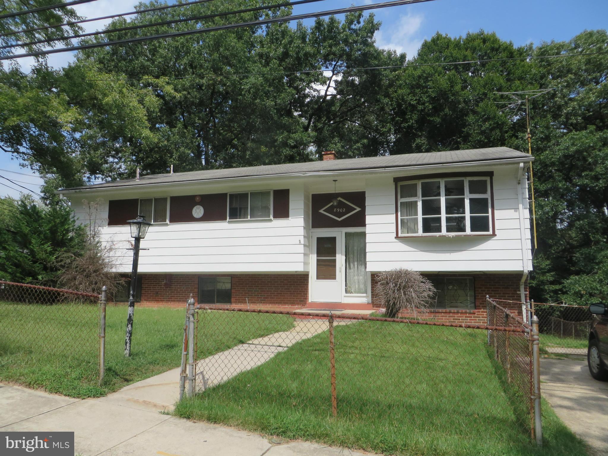 a front view of a house with a garden and plants