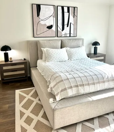 a bedroom with a bed and a night stand next to a window