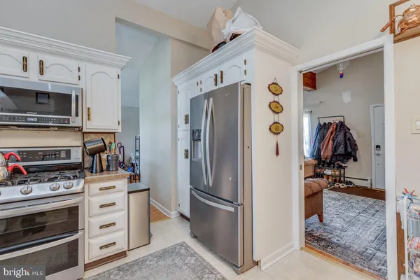 a kitchen with stainless steel appliances a refrigerator stove and cabinets