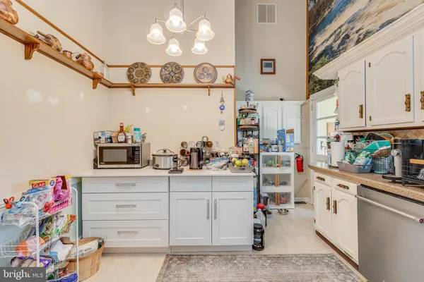 a kitchen with cabinets appliances and wooden floor