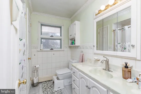 a bathroom with a granite countertop sink a toilet and a mirror