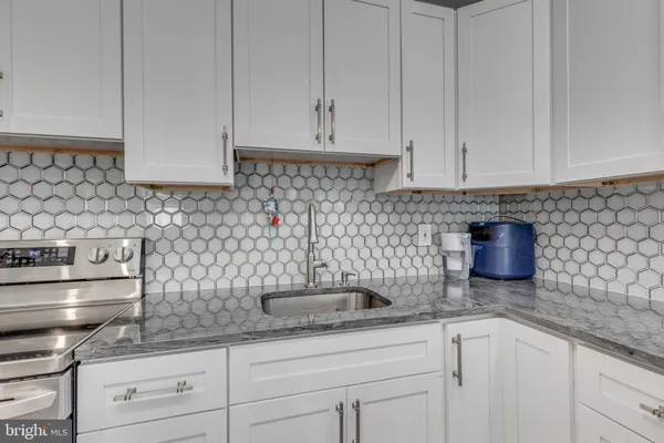a kitchen with stainless steel appliances granite countertop a sink a stove and cabinets