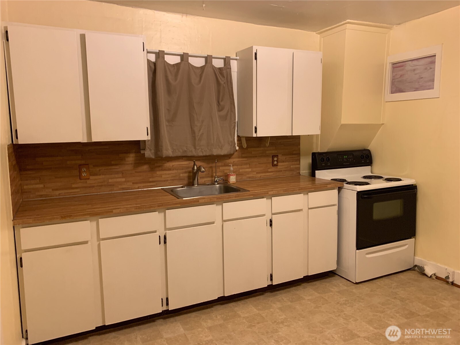 910 Northwest 52nd Street Seattle, WA 98107 - Photo 15 of 22 a kitchen with stainless steel appliances granite countertop a sink a stove and white cabinets