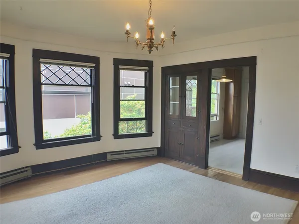 a view of a big room with windows and chandelier