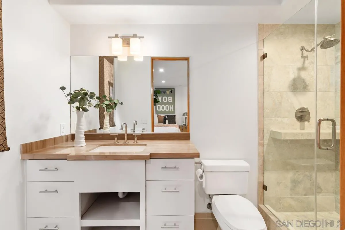 5486 Rutgers Road La Jolla, CA 92037 - Photo 34 of 47 a bathroom with a sink vanity granite toilet and a mirror