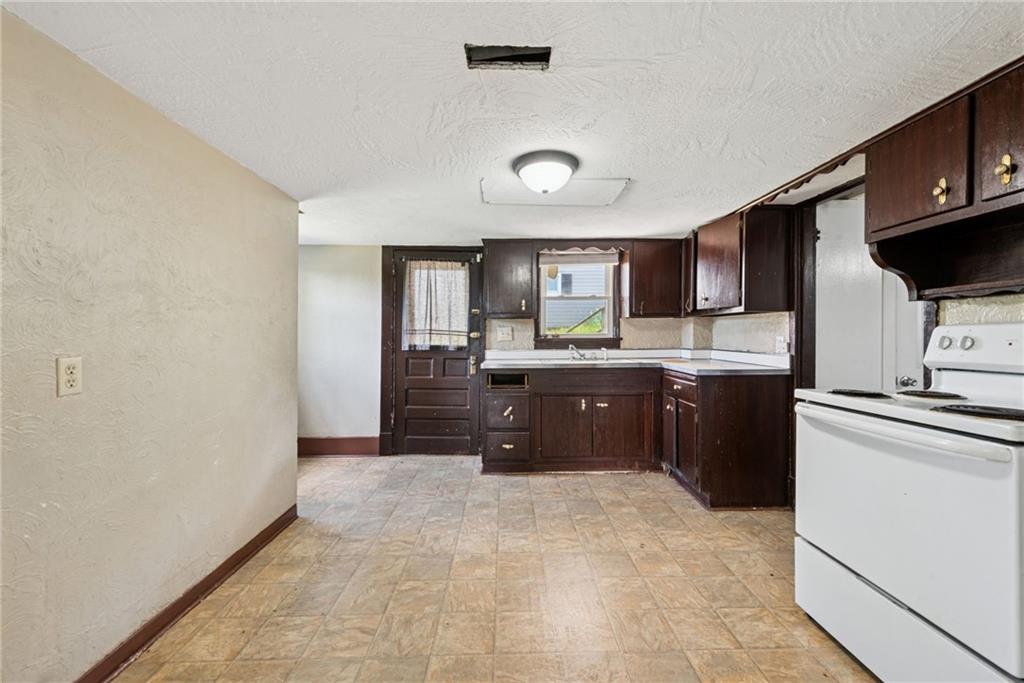 1442 Rostraver Street Monessen, PA 15062 - Photo 24 of 29 a kitchen with stainless steel appliances a refrigerator and a stove top oven
