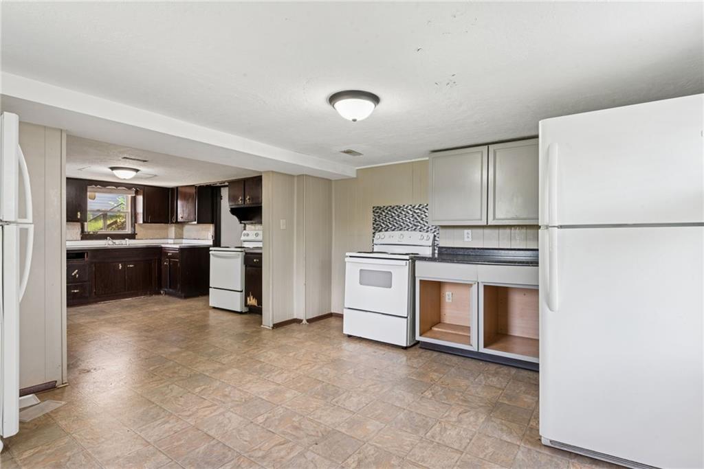 1442 Rostraver Street Monessen, PA 15062 - Photo 26 of 29 a kitchen with white cabinets and white appliances