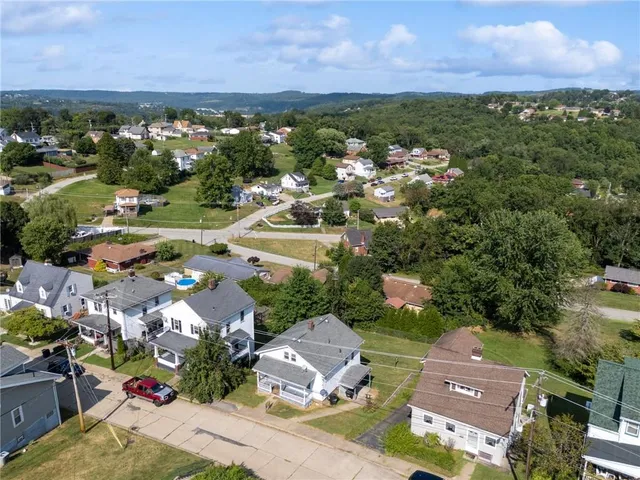 an aerial view of residential houses with outdoor space and street view