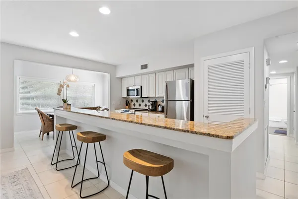 a kitchen with stainless steel appliances granite countertop a sink and a refrigerator