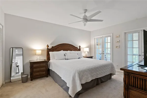 a bedroom with a bed a chandelier and a dresser
