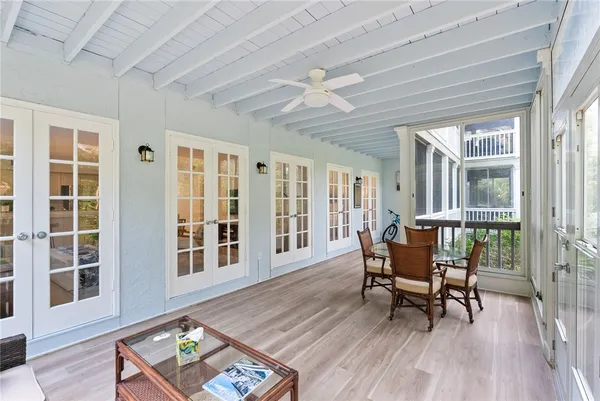 a dining room with wooden floor and large windows