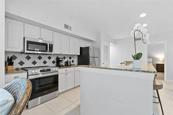 a kitchen with granite countertop a sink stove and microwave