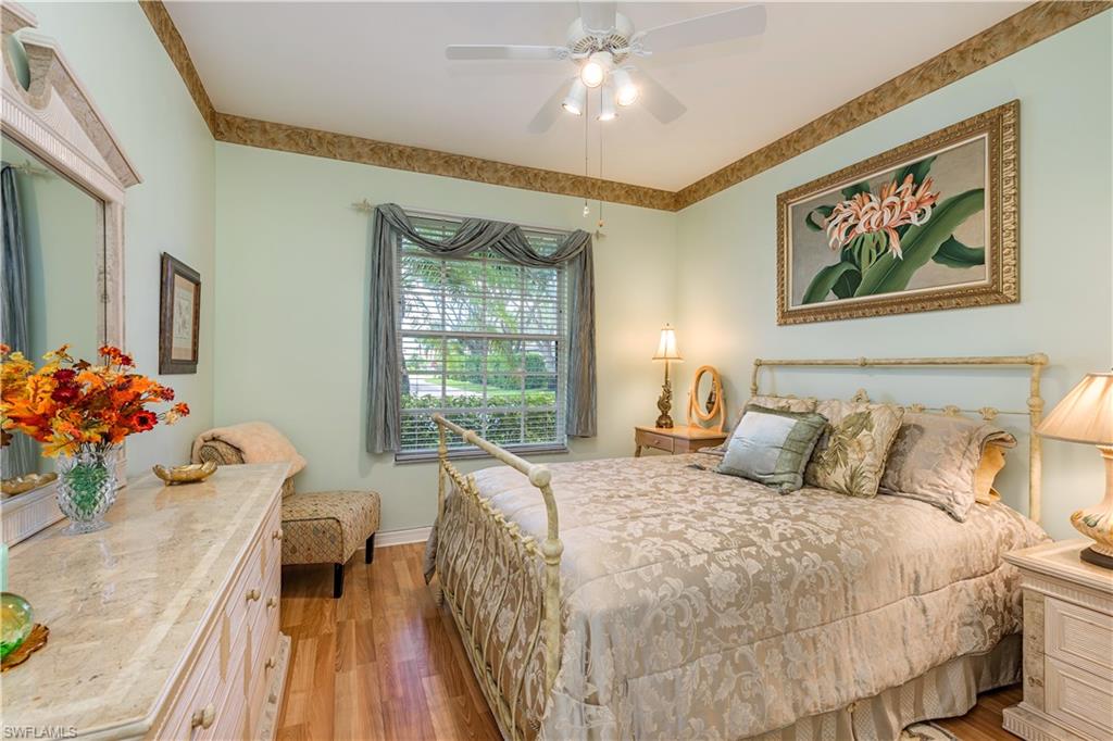 1905 Timarron Way Naples, FL 34109 - Photo 9 of 25 a bedroom with a bed and a chandelier
