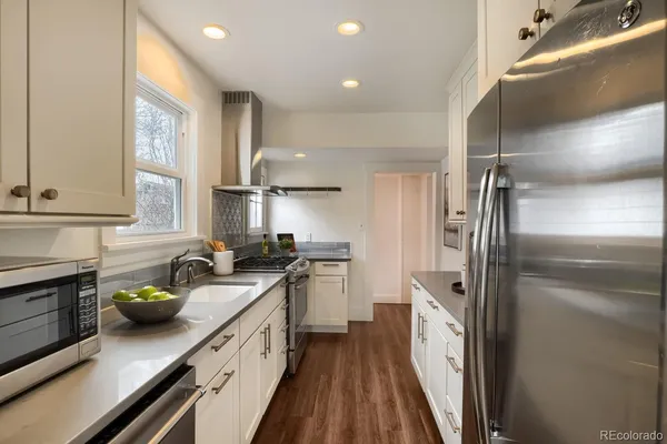 a kitchen with stainless steel appliances a sink stove and refrigerator
