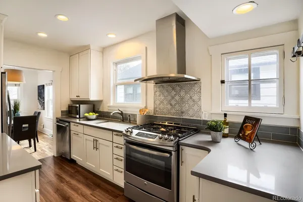 a kitchen with a stove a sink a refrigerator and cabinets