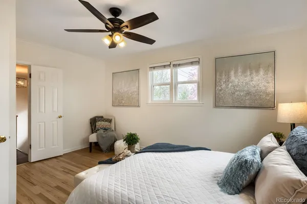 a bedroom that has a bed and a chandelier fan
