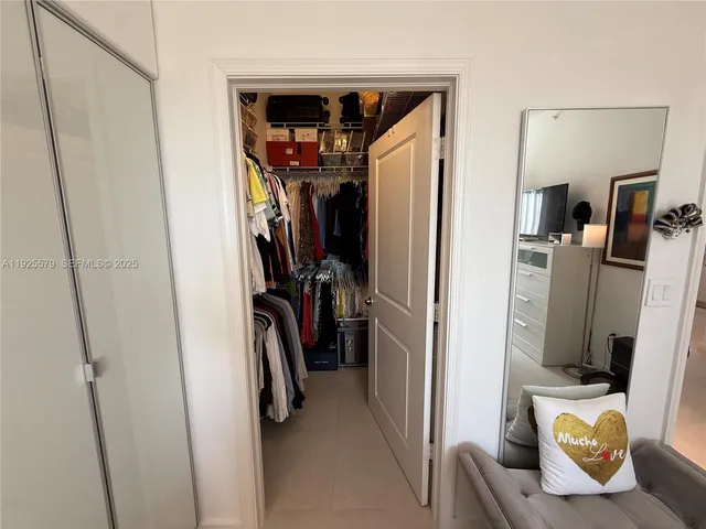 a view of walk in closet with clothes and shoes