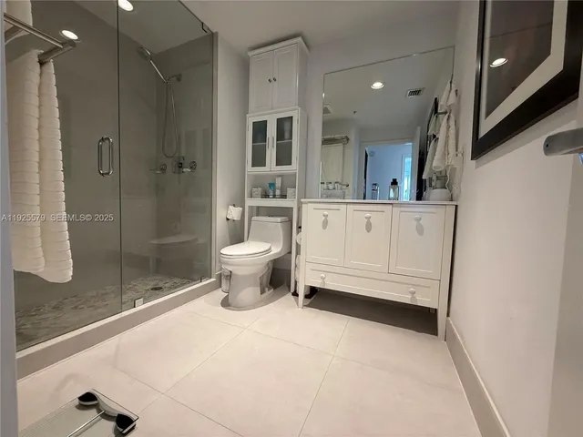 a bathroom with a granite countertop sink a toilet and shower