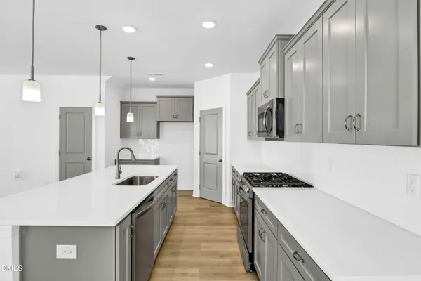 a kitchen with stainless steel appliances a sink stove and refrigerator