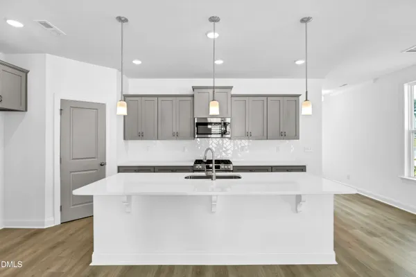 a kitchen with kitchen island stainless steel appliances a sink a center island a stove and a window
