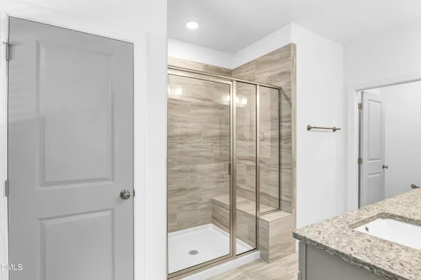 a bathroom with a granite countertop sink and shower