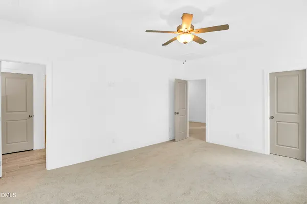 an empty room with a ceiling fan and a window