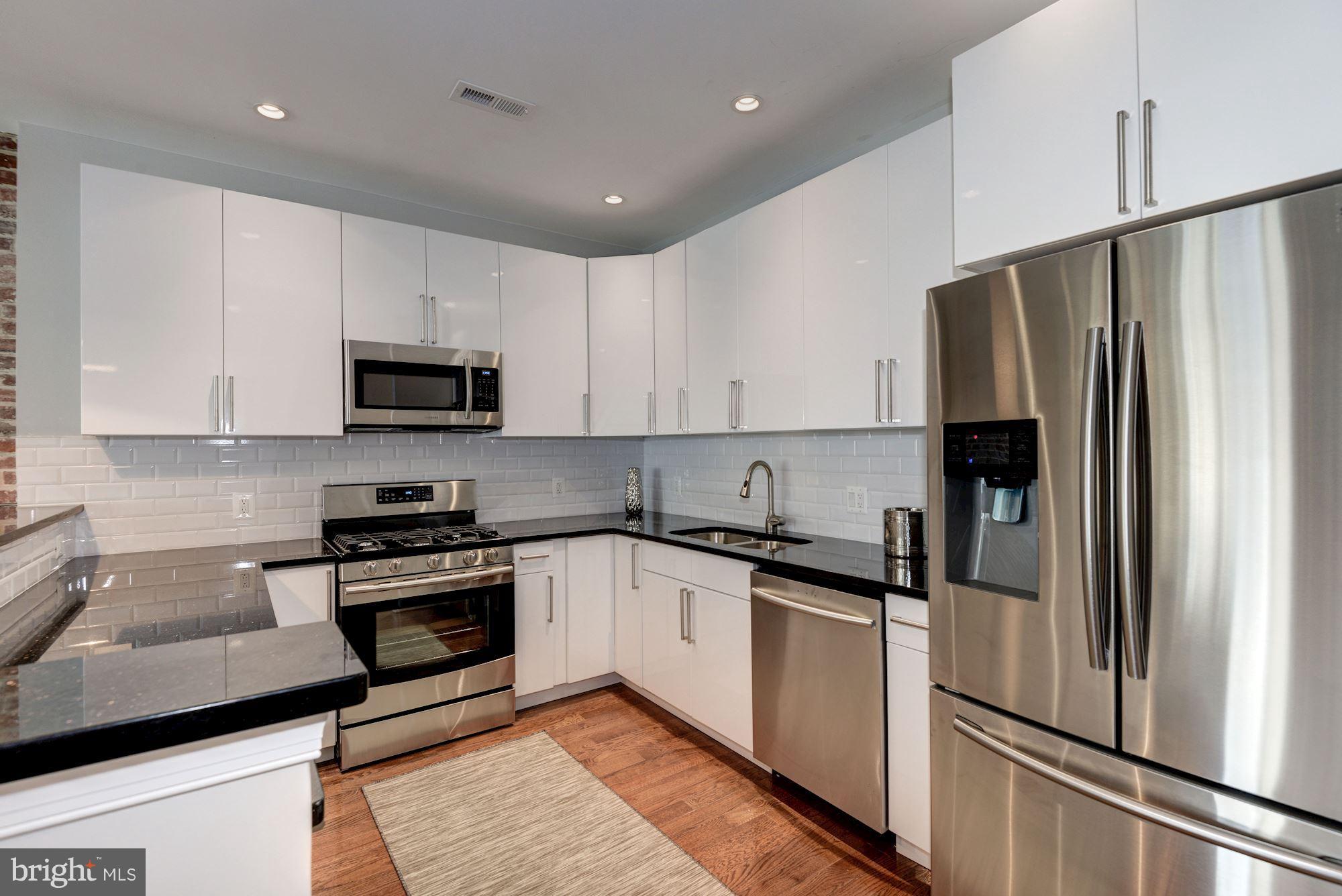 1616 6th Street Northwest, Unit 2 Washington, DC 20001 - Photo 1 of 20 a kitchen with stainless steel appliances granite countertop a refrigerator sink and stove