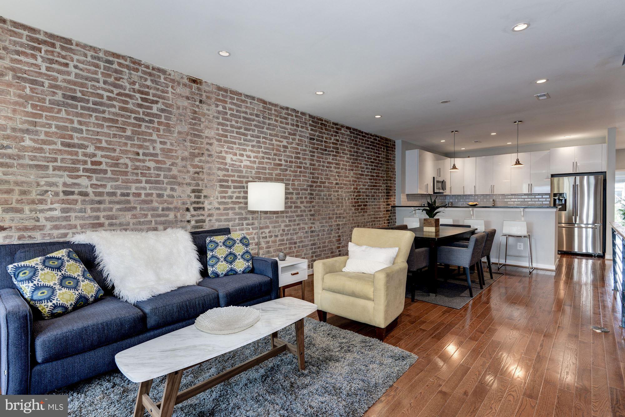 1616 6th Street Northwest, Unit 2 Washington, DC 20001 - Photo 2 of 20 a living room with couches and kitchen view with wooden floor