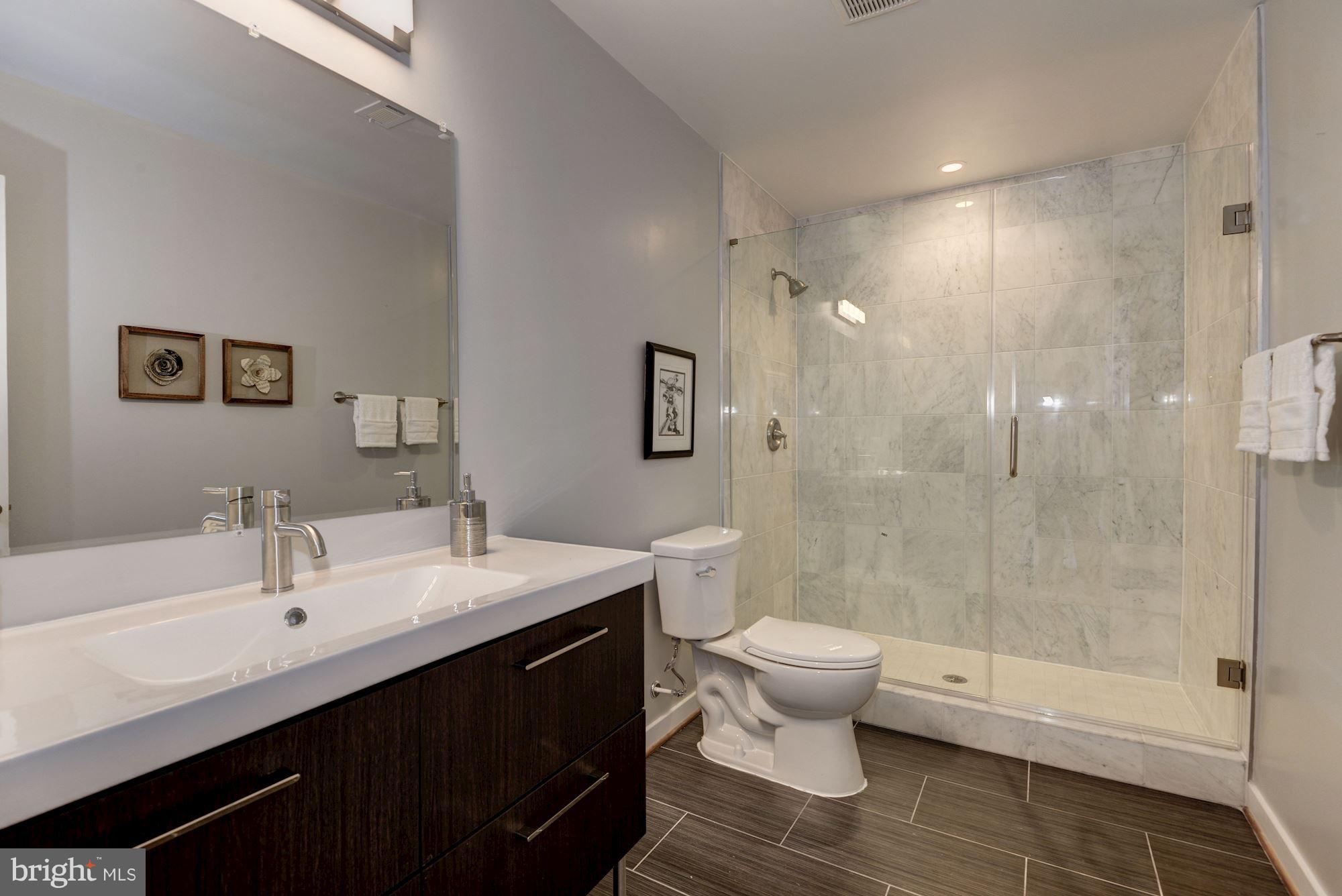 1616 6th Street Northwest, Unit 2 Washington, DC 20001 - Photo 14 of 20 a bathroom with a double vanity sink toilet and shower