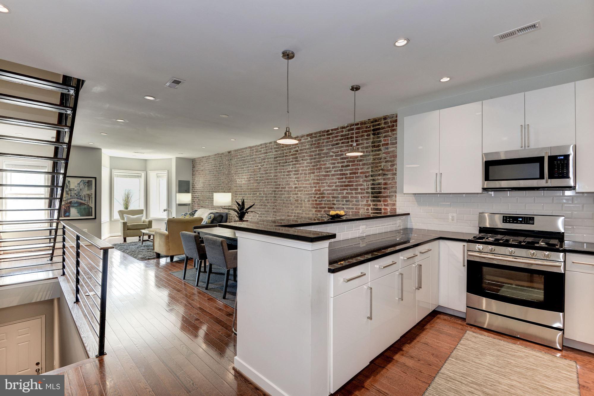1616 6th Street Northwest, Unit 2 Washington, DC 20001 - Photo 5 of 20 a kitchen with stainless steel appliances granite countertop a stove and a wooden floors