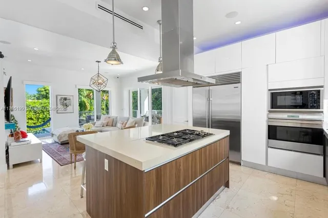 a kitchen with a stove a sink a kitchen island with wooden cabinets and floor