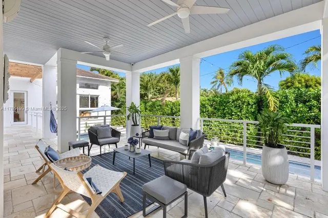 a living room with patio furniture and a potted plant