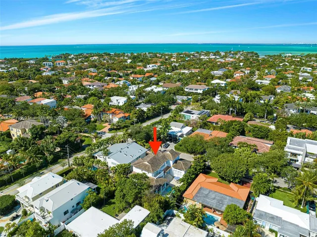 an aerial view of residential houses with outdoor space and trees