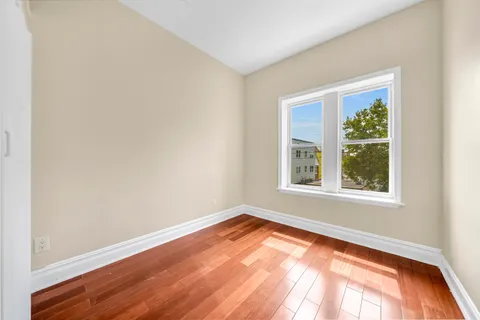 an empty room with wooden floor and a window