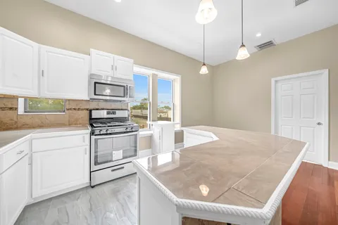 a kitchen with stainless steel appliances granite countertop a sink a stove and a refrigerator